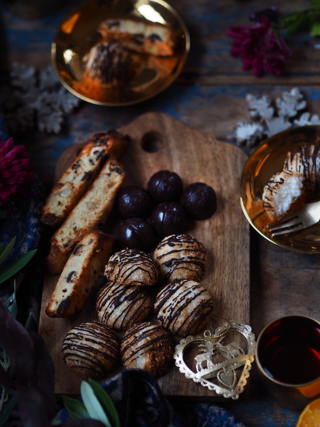 Nine Tea Cups Bakery Gluten Free Dairy Free Christmas Keto Box - A selection of keto friendly chocolate and orange biscotti, coconut macaroons and chocolate mints on a christmas table with purple flowers and gold tableware