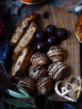 Load image into Gallery viewer, Nine tea cups bakery gluten-free, dairy-free keto selection box: chocolate and orange biscotti, coconut macaroons and chocolate mints on a christmas table with a heart shaped christmas decoration 
